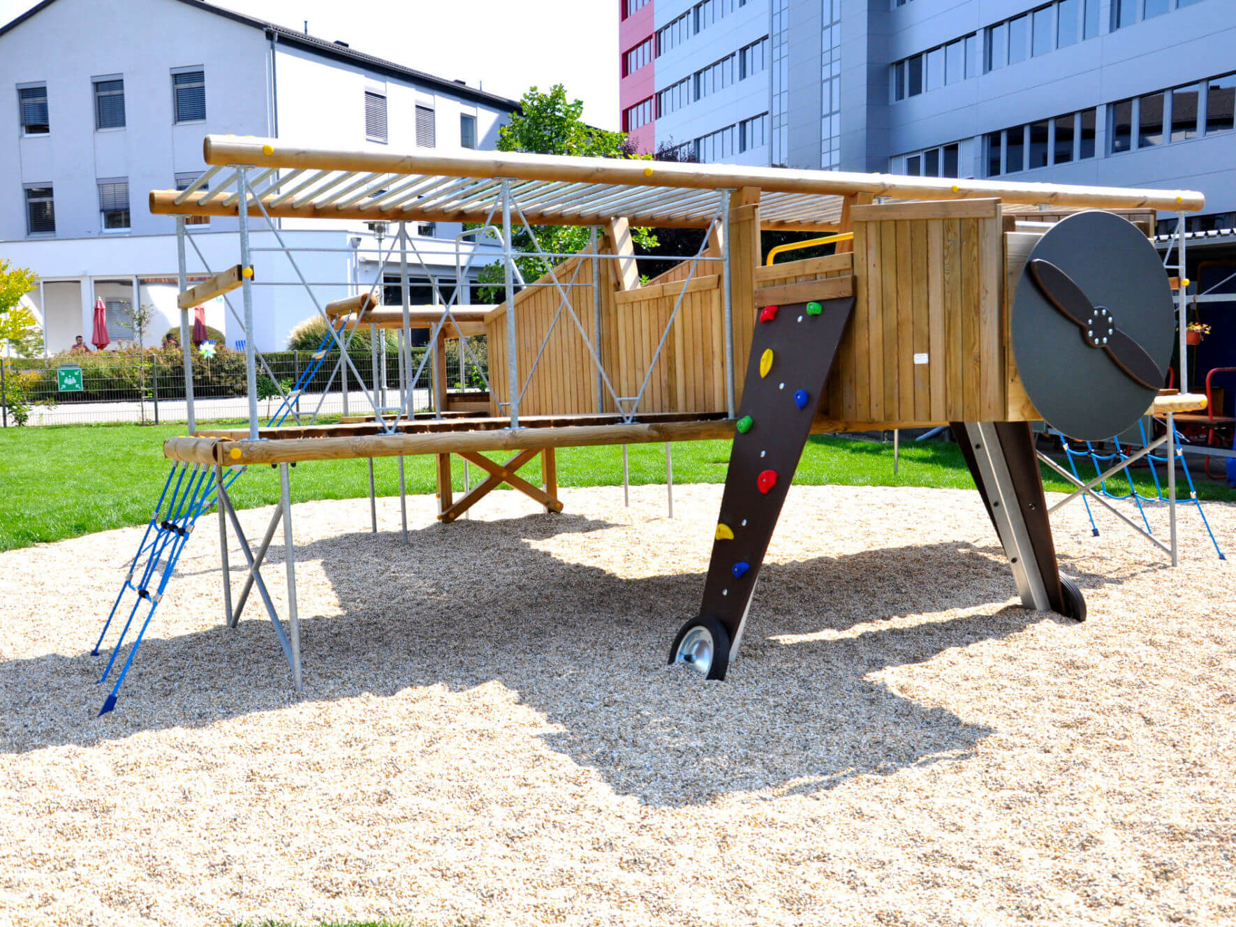Ein Kletter-Flugzeug aus Holz auf einem Spielplatz.